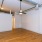 a room with a wood floor and a white wall with a light