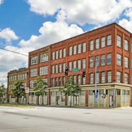 exterior of building with green turf and some seating