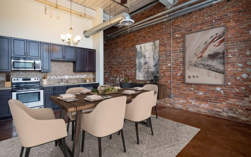 a kitchen with a brick wall and a table with chairs